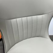 A striking chair with a terracotta leather seat, vertical stitching, and contrasting black legs image