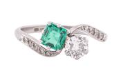 EDWARDIAN DIAMOND AND EMERALD CROSS-OVER RING, CIRCA 1910