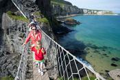 Woman and child crossing Carrick-a-rede Rope Bridge, County Antrim, Northern Ireland.