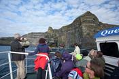 Tourists admiring the Cliffs of Moher from a scenic boat tour, Co Clare, Ireland.
