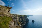 Walker on the Cliffs of Moher Coastal Path, County Clare, Ireland.