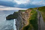Walker above the Cliffs of Moher, County Clare, Ireland. image