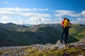 Walker at the summit of Knocknahillion, Maumturk Mountains, Co Mayo, Ireland.