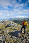 Walker looking towards Killary Harbour from Letterbreckaun, Maumturk Mountains, Co Mayo, Ireland.