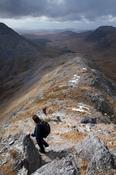 Descending the narrow ridge from Bencollaghduff to Maumina, Twelve Bens, Connemara, Co Galway, Ireland.