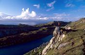 Walker looking over Lough Akeen, Sheep's Head Way, Co Cork, Ireland.