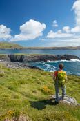 Hiker looking to Illanebeg islet, Dursey Island, Beara Peninsula, County Cork, Ireland.