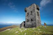 Hiker and signal tower at the summit of Cnoc Bolais, Dursey Island, Beara Peninsula, County Cork, Ireland.