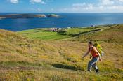 Hiker above the hamlet of Ballynacallagh, Dursey Island, Beara Peninsula, County Cork, Ireland.