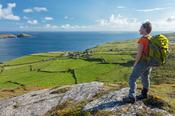 Hiker above the hamlet of Ballynacallagh, Dursey Island, Beara Peninsula, County Cork, Ireland.