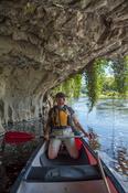 Canoeist beneath a limestone cliff, Blackwater River, Mallow, County Cork, Ireland.