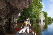 Canoeist beneath a limestone cliff, Blackwater River, Mallow, County Cork, Ireland.
