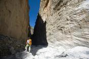 Hiker beneath the Iron Gates, Samaria Gorge, Samaria National Park, Crete, Greece.