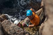 Rock climbers on a sea stack near Gwedore, County Donegal, Ireland.