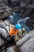 Rock climbers on a sea stack near Gwedore, County Donegal, Ireland.