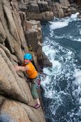 Iain Millar climbing a sea stack near Gwedore, County Donegal, Ireland.