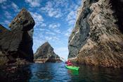 Sea kayaker exploring seastacks near Port, County Donegal, Ireland.