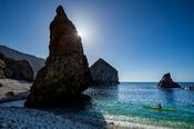 Sea kayaking beside stacks and pinnacles beneath Slieve Tooey, County Donegal, Ireland.