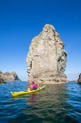 Sea kayaking past a massive stack near Port, Glencolmcille, County Donegal, Ireland.