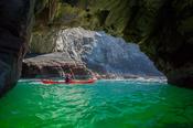 Sea kayaker exploring a cave near Glencolmcille, County Donegal, Ireland.