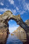 Sea kayaking beneath a natural arch near Sturrall, Glencolmcille, County Donegal, Ireland. image