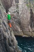Rock climber on the eastern shore of Owey Island, County Donegal, Ireland.