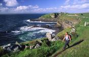 Walker in front of Kilbarron Castle, Creevy Coastal Path, Co Donegal, Ireland.