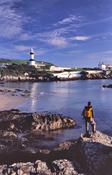 Walker beneath Inishowen Lighthouse, Dunagree Point, Inishowen, Co Donegal, Ireland.