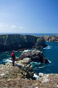 Walker looking over the cliffs of northeast Tory Island, Co Donegal, Ireland. image