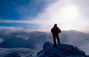 Winter walker at the summit of Slieve Bearnagh, Mourne Mountains, Co Down, Northern Ireland.