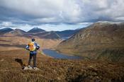 Walker looking down the Silent Valley from Slievenaglogh, Mourne Mountains, Co Down, Northern Ireland.