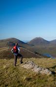 Walker taking in the view from the summit of Slieve Muck, Mourne Mountains, Co Down, Northern Ireland.