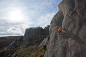 Climber on 'Electra' (E1 5b), North Tor, Slieve Binnian, Mourne Mountains, County Down, Northern Ireland.
