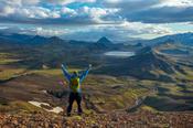 Hiker looking over the mountains and lake at Alftavatn, from Jokultungur on the Laugavegur hiking trail. Central Highlands, Sudhurland, Iceland.