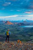 Evening hiker looking over the mountains and lake at Alftavatn, from Jokultungur on the Laugavegur hiking trail. Central Highlands, Sudhurland, Iceland.
