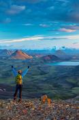 Evening hiker looking over the mountains and lake at Alftavatn, from Jokultungur on the Laugavegur hiking trail. Central Highlands, Sudhurland, Iceland.