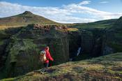 Hiker beside the upper Skoga river, Fimmvorduhals trail, Sudhurland, Iceland.