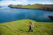 Hiker exploring the Storhofdi peninsula on Heimaey island, Westman Islands, Sudhurland, Iceland.