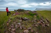 Person beside the ruins of an old fishing settlement at Brunnar, Latrabjarg Peninsula. Westfjords, Iceland.