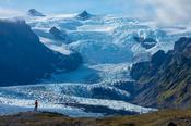Person dwarfed by the ice fall of Kviarjokull glacier. Vatnajokull ice cap, Sudhurland, south east Iceland.
