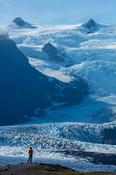 Person dwarfed by the ice fall of Kviarjokull glacier. Vatnajokull ice cap, Sudhurland, south east Iceland. image