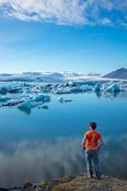 Person on the shore of Jokulsarlon glacier lagoon, beneath Vatnajokull glacier. Sudhurland, south east Iceland. image