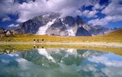 Walkers reflected beneath Mt Blanc, Tour of Mont Blanc, Italian Alps, Italy.