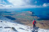 Winter walker near the summit of Brandon Mountain, Dingle Peninsula, Co Kerry, Ireland.