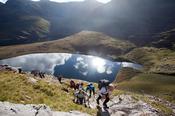 Walkers above Lough Gouragh on the ascent of Carrauntoohill, MacGillycuddy's Reeks, County Kerry, Ireland.