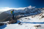 Winter walker beneath Brandon Peak, Dingle Peninsula, County Kerry, Ireland.