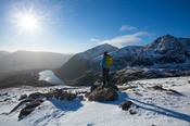 Winter walker looking over Lough Cruite from Brandon Mountain, Dingle Peninsula, County Kerry, Ireland.