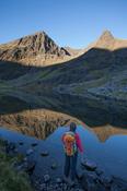 Walker and Lough Gouragh beneath Carrauntoohil, Hag's Glen, MacGillycuddy's Reeks, County Kerry, Ireland.