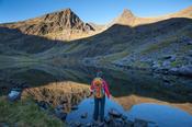 Walker and Lough Gouragh beneath Carrauntoohil, Hag's Glen, MacGillycuddy's Reeks, County Kerry, Ireland.