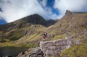 Hiker and Lough Gouragh beneath Carrauntoohil, MacGillycuddy's Reeks, County Kerry, Ireland.